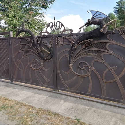 Close-up of a single sculpted dragon head on the wrought iron entrance gate