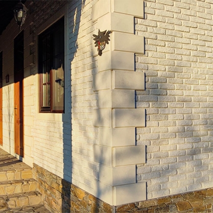 Covered porch with carved dragon eave board, brick pillars, and a stone-paved walkway