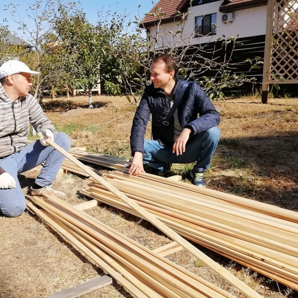 Craftsmen preparing wood slats for the pergola lattice panels on site