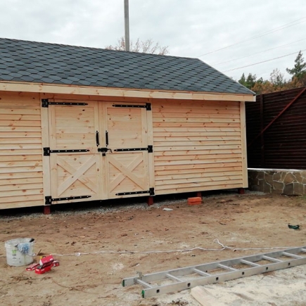 Finished timber storage shed with double barn doors and a stone foundation