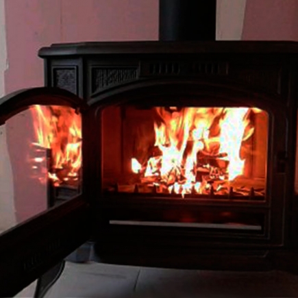 Roaring fire inside the cast-iron wood-burning stove