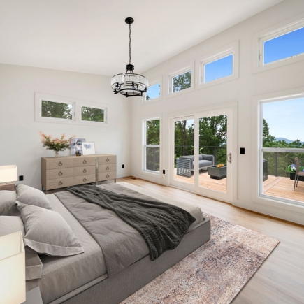 Bedroom with vaulted ceiling, chandelier, and sliding door to a private deck