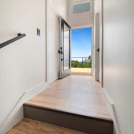 Entry hallway with open door leading out to the deck and mountain view