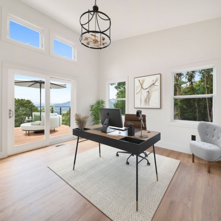 Home office with desk and chair beside sliding glass doors to the deck
