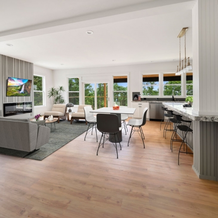 Open-concept living, dining, and kitchen area with fireplace and mountain-view windows