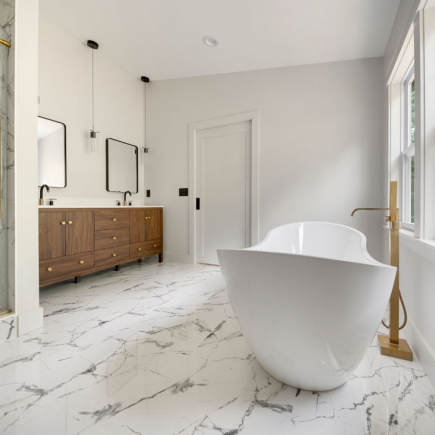 Primary bathroom with dark wood double vanity, pendant lighting, and freestanding tub