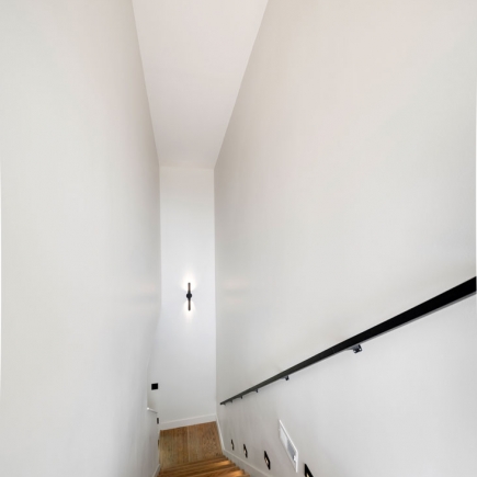Stairway hallway with wall sconce leading down to the main level