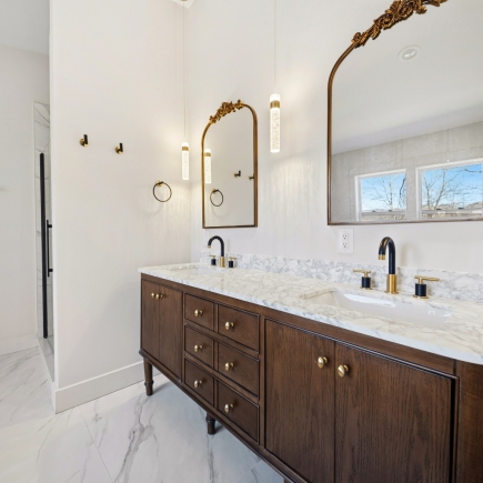 Bathroom double vanity in dark wood with marble countertop and ornate mirrors