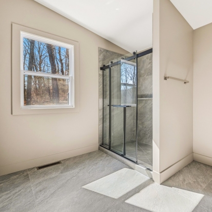 Bathroom with glass-enclosed walk-in shower and window