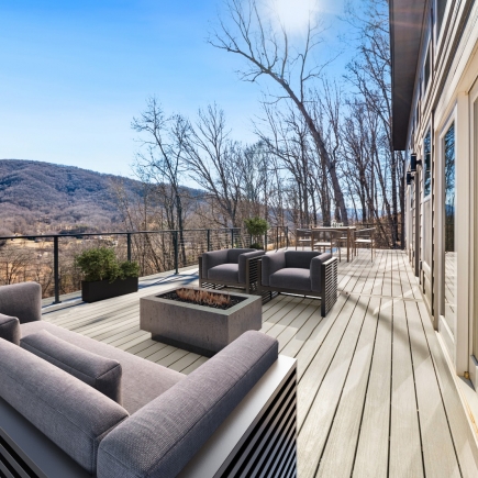 Covered deck with lounge seating, fire pit table, and mountain view