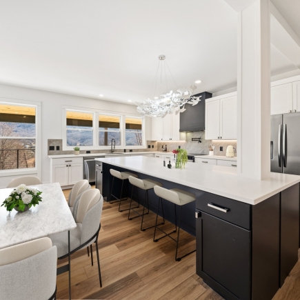 Kitchen island with bar seating, dining table, and statement chandelier