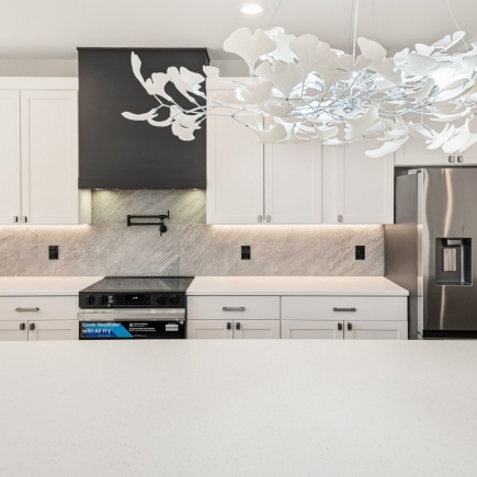 Kitchen range hood with sculptural pendant light and marble backsplash